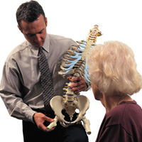 MD showing patient human spine model